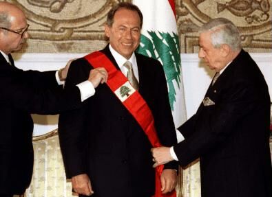 Outgoing President Elias Harwi (R) fixes the band of honor to President Emile Lahoud