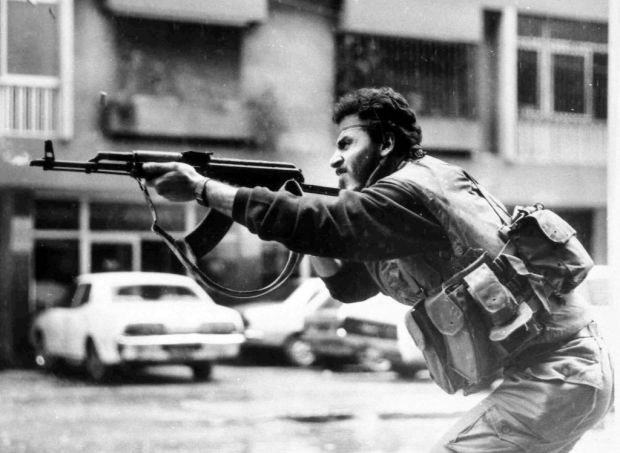 A Shiite Muslim AMAL militiaman fires his AK-47 assault rifle during skirmishes with Druse irregulars on Corniche Mazraa road, West Beirut, Lebanon, Feb. 20, 1987. (photo credit: AP)