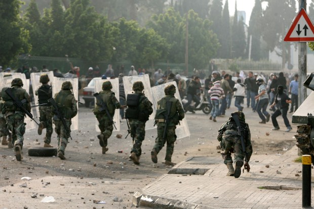 Soldiers advance towards stone-throwing Sunni Muslim supporters of outgoing Prime Minister Saad Hariri near Tariq al-Jadidah in Beirut January 25, 2011. (REUTERS/Hasan Shaaban)